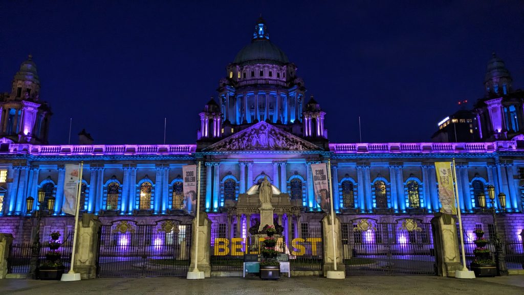 Belfast City Hall lit up in teal and purple