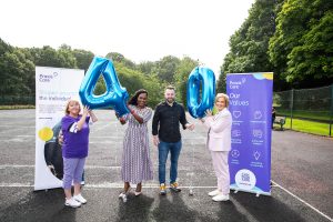 Praxis Care's Louise Lyons, Mayor of Derry City and Strabane, Lilian Seenoi-Barr, the SDLP leader and MP for Foyle, Colum Eastwood, and Praxis Care's Rosemary Doherty stand together holding up a large 4 and 0 balloon